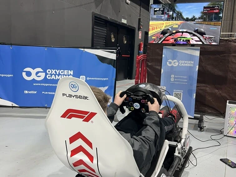 Hombre jugando con simulador de conducción PC durante une vento tecnológico en Valencia